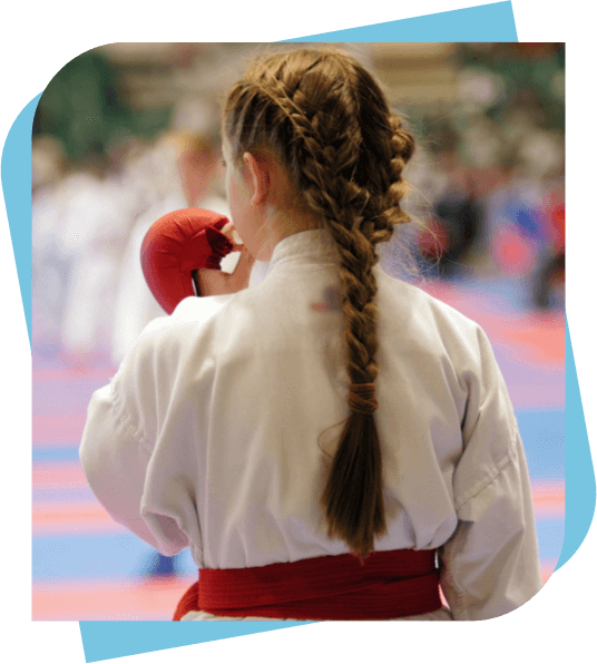 young girl at a martial arts tournament putting her mouthguard in her mouth