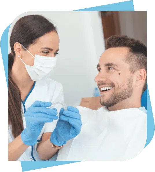 patient smiles at his dentist while she shows him his new custom mouthguard