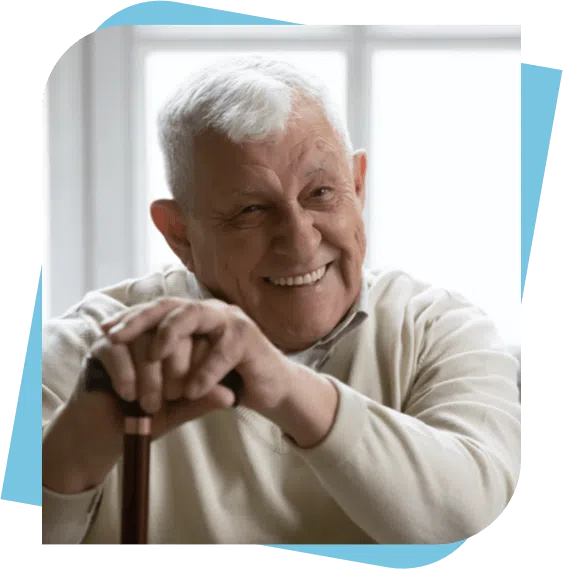 Elderly man smiling while holding his cane.