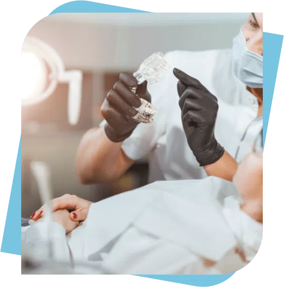 Dentist shows a patient a dental model