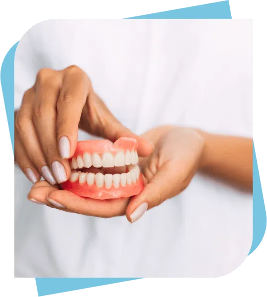 dentist holding a full set of upper and lower dentures in her hands
