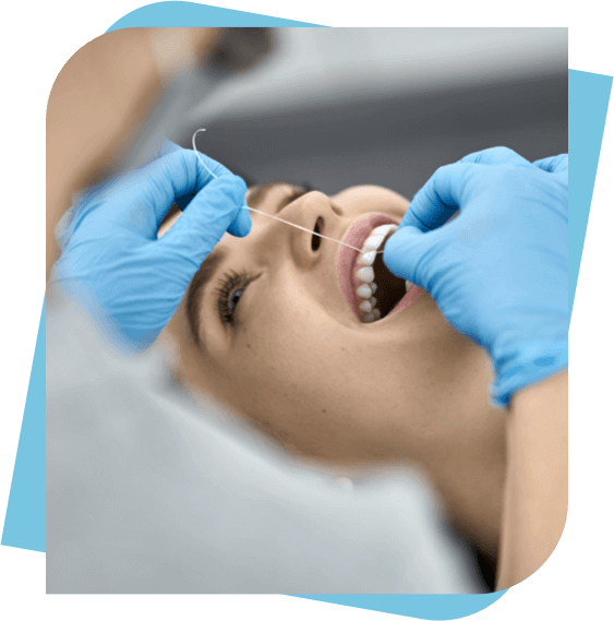 Woman having her teeth flossed by her dentist
