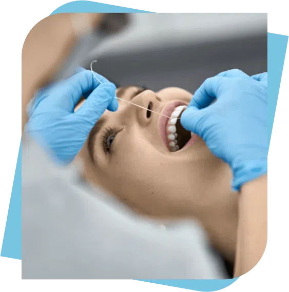 Woman having her teeth flossed by her dentist