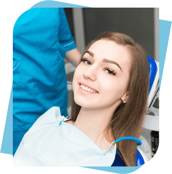 teenage girl smiling while sitting in a dental chair.