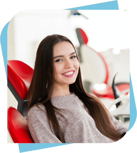 woman sitting in a dental chair and smiling after having her teeth cleaned