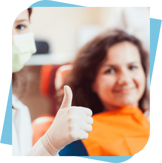 dentist giving a thumbs up while a patient smiles in the background.