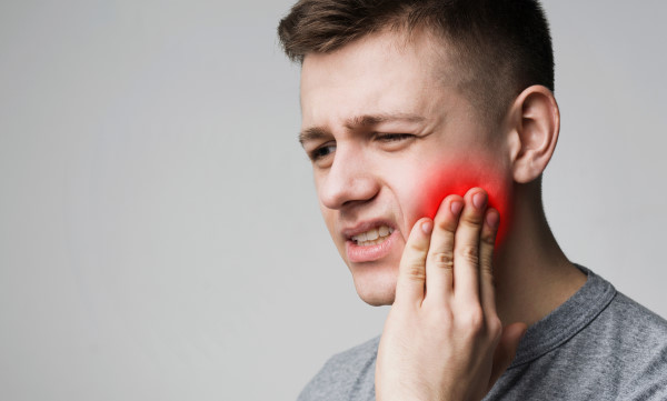 man experiencing discomfort and pain in jaw